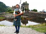 Bagpiper vor Eilean Donan Castle