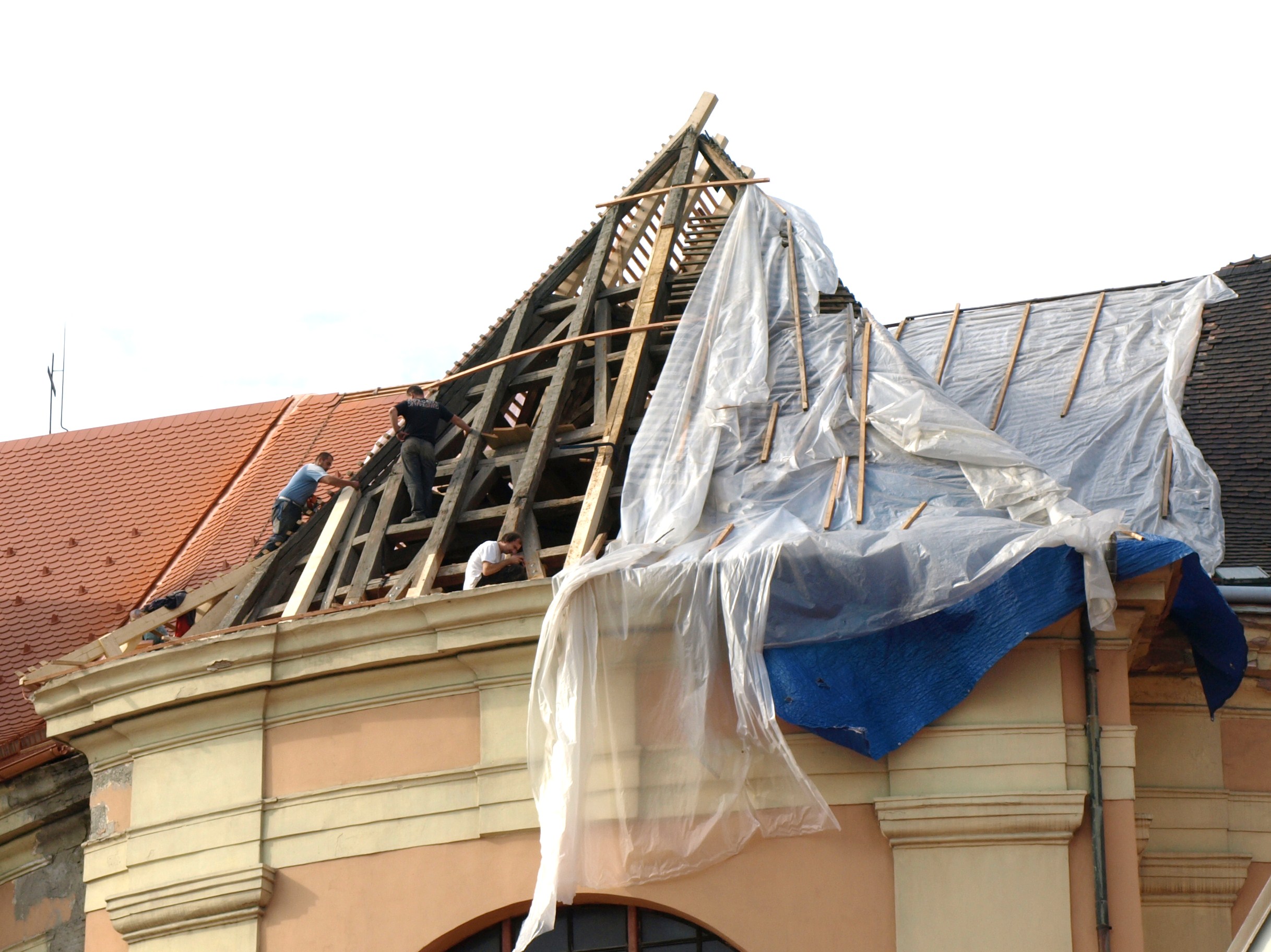 Zimmerleute und Dachdecker bei der Arbeit an einer alten Kirche